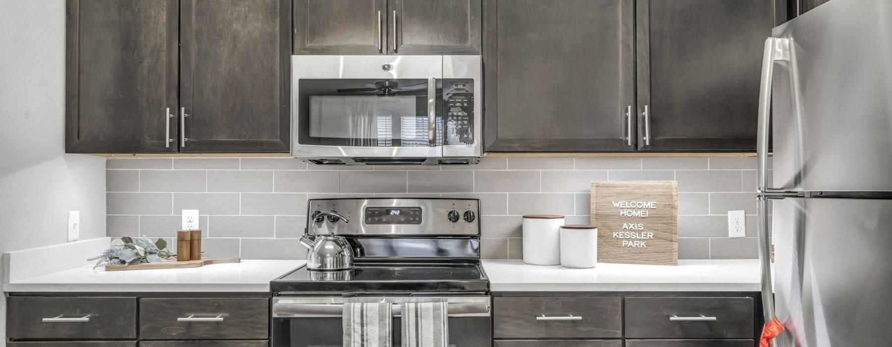 Modern kitchen with stainless steel appliances in Axis Kessler Park's 1, 2, or 3 Bedroom Apartments in Dallas